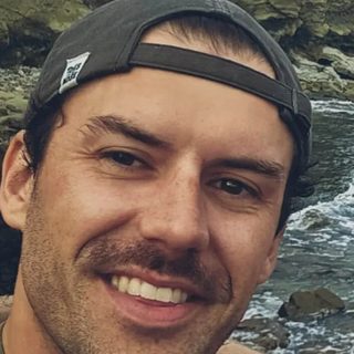 Michael Kuhlman smiling, outdoors in a backwards cap